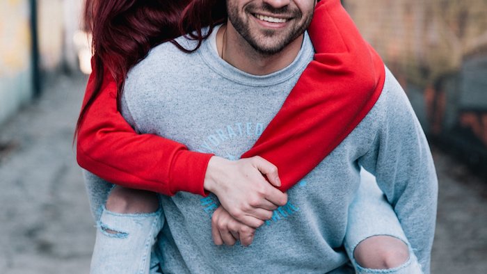 A woman piggy back riding on her man.