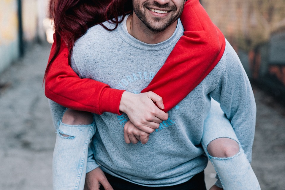 A woman piggy back riding on her man.